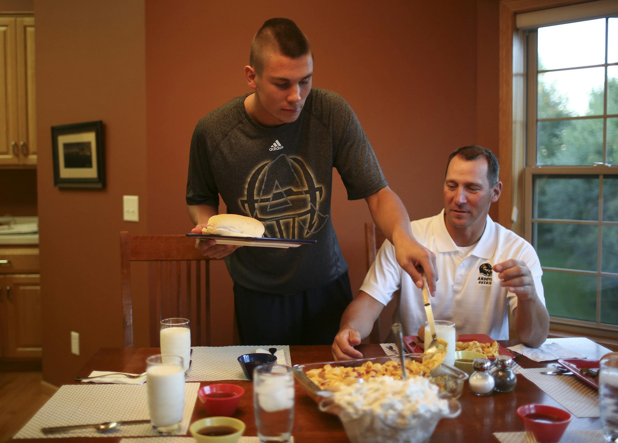 Connor Wilkie and his father, Rich, served themselves dinner. Connor has gone from ball boy to star senior quarterback under the watch of Rich, the only coach Andover has ever had.