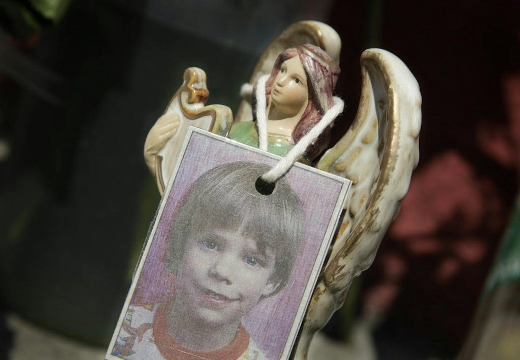 FILE- In this May 28, 2012, file photo, a photograph of Etan Patz hangs on an angel figurine, which is part of a makeshift memorial in the SoHo neighborhood of New York. Prosecutors once again must sum up their case against a man accused of killing Patz in New York City 37 years ago. Closing arguments in the case against Pedro Hernandez began Monday, Jan. 30, 2017, in Manhattan and were set to continue Tuesday.