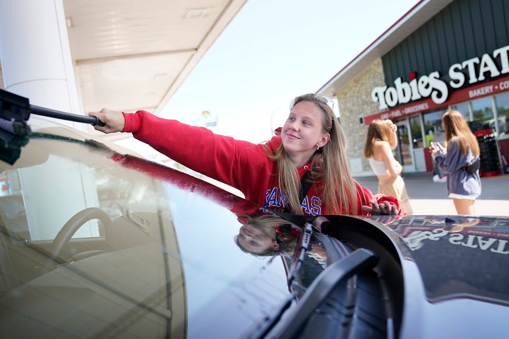 Anna Janckila of Minneapolis cleaned the windshield of her Jeep at Tobies Station in Hinckley. She and her friends were on their way to Duluth; she estimated that it takes $95 to $100 to fill her Jeep these days.