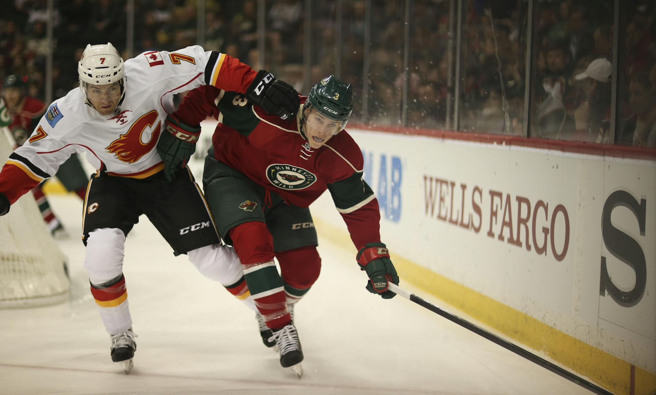 The Minnesota Wild faced the Calgary Flames in an NHL hockey game Monday night, March 3, 2014 at Xcel Energy Center in St. Paul. The Wild's Charlie Coyle and Calgary's T.J. Brodie kept their eyes on the puck as they followed it into the corner in the first period. ] JEFF WHEELER &#x201a;&#xc4;&#xa2; jeff.wheeler@startribune.com