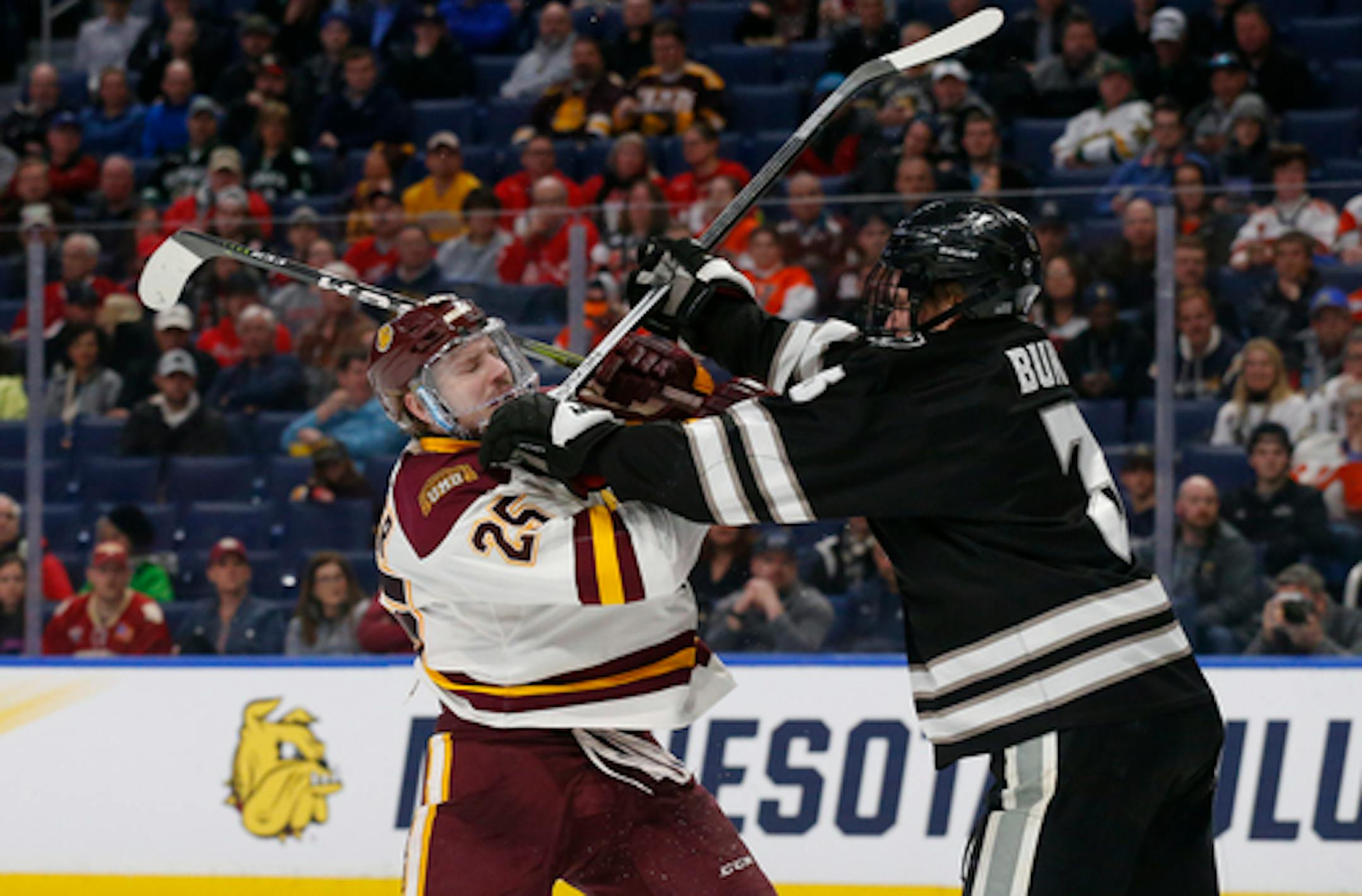 Minnesota Duluth forward Peter Krieger (25) and Providence defenseman Davis Bunz battled in front of several empty seats during the April 11 NCAA Frozen Four semifinals in Buffalo, N.Y.