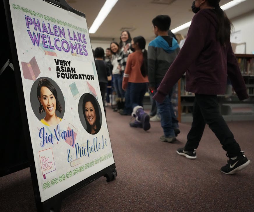 A welcome sign shows the faces of Gia Vang, former KARE-11 news anchor, and Michelle Li in the library of Phalen Lake Hmong Studies Magnet school.
