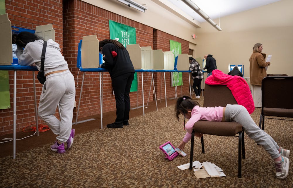 Ivy Rua-Torres, 5, waits while her mother, Jenna Rua-Torres, left, votes on Election Day at First Covenant Church in St. Paul on Tuesday.