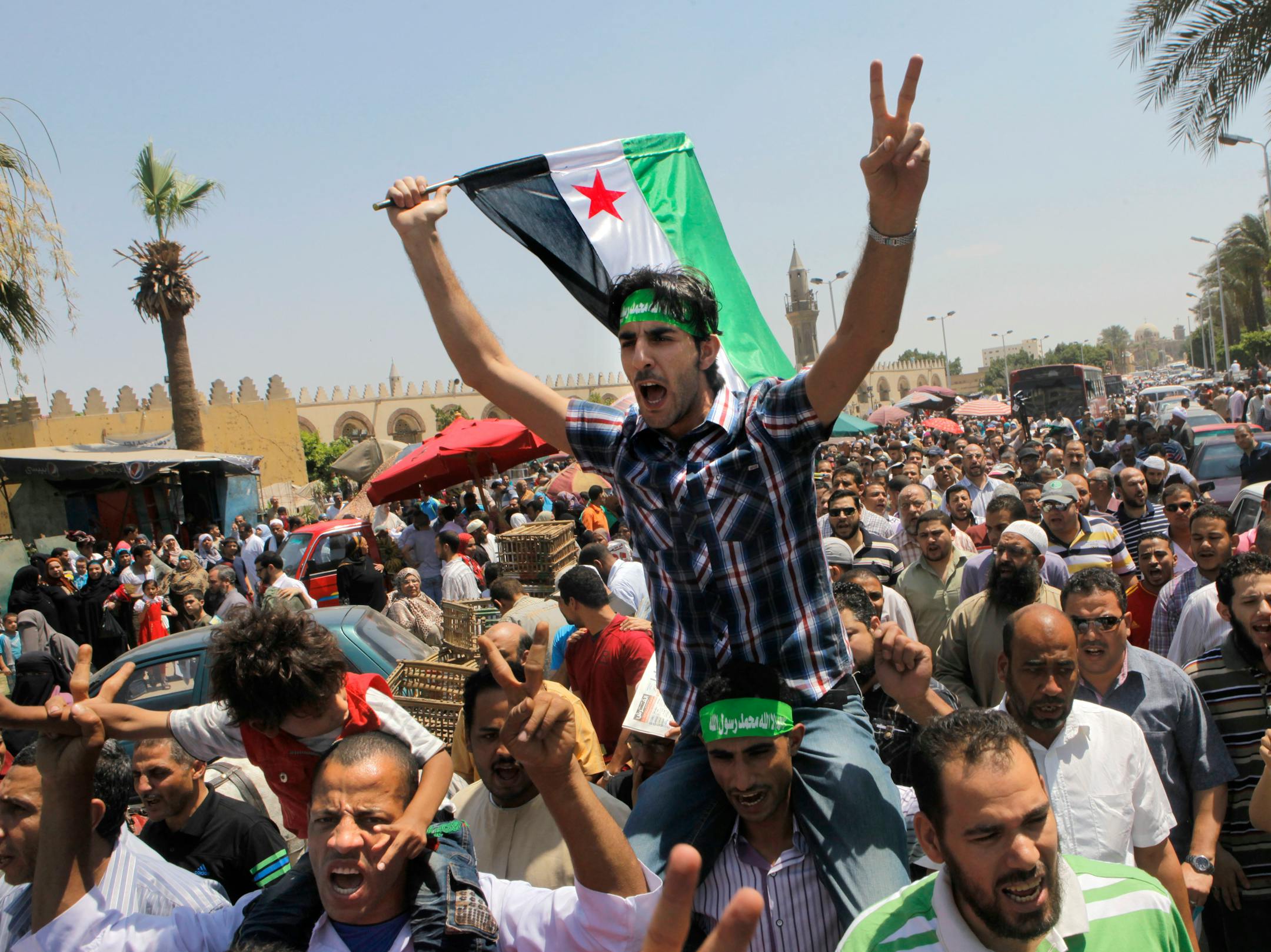 Egyptian Salafis shout slogans against Syrian President Bashar Assad as one waves a Syrian revolutionary flag during a rally after the Friday prayers at Amr Ibn Al As mosque, in Cairo, Egypt, Friday, June 14, 2013. Syrians are being killed at an average rate of 5,000 per month, the United Nation said Thursday as it raised the overall death toll in the civil war to nearly 93,000, with civilians bearing the brunt of the attacks.