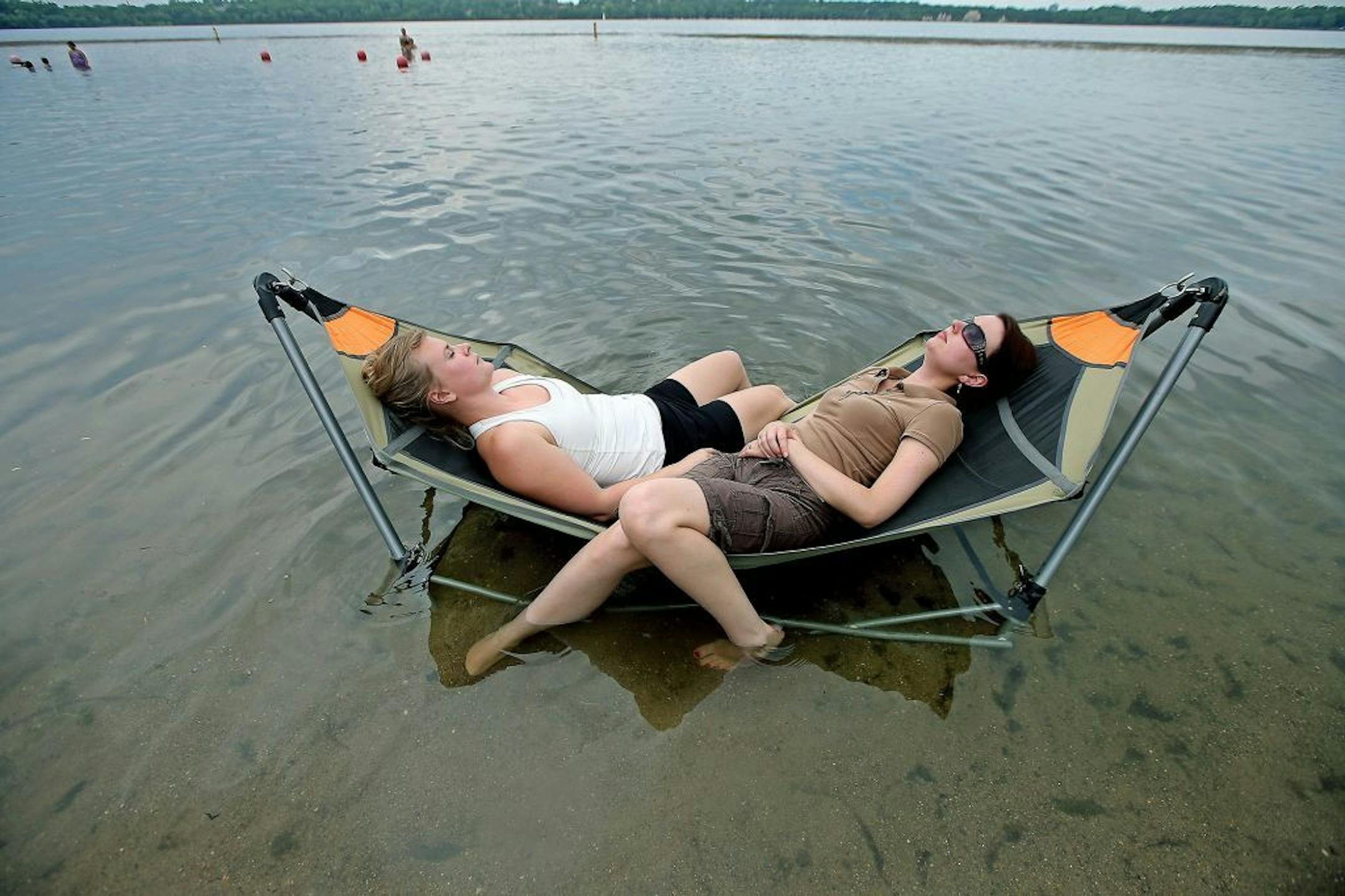 Like many escaping the day's heat, Miranda Ebner, left, and Samantha Abbott, right, took to the water to keep cool at Lake Harriet on Friday in Minneapolis.