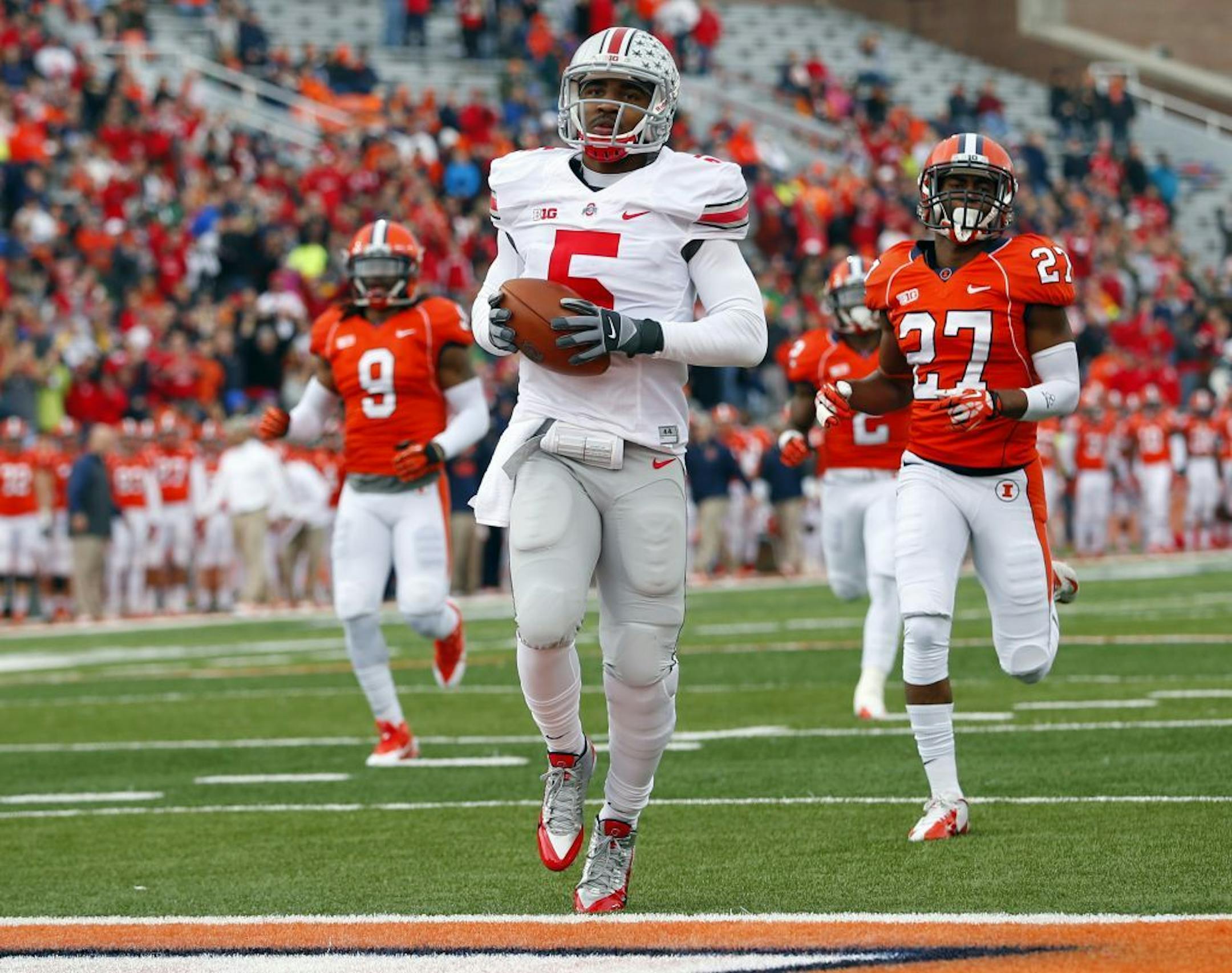 Ohio State quarterback Braxton Miller (5) scores on a 70-yard touchdown run as Illinois defensive back Eaton Spence (27) and defensive back Earnest Thomas III (9) chase him during the first half of an NCAA college football game on Saturday, Nov. 16, 2013, in Champaign, Ill.
