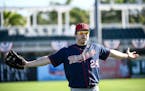 Minnesota Twins center fielder J.B. Shuck (24) gestured to center fielder Byron Buxton (25) while they talked Monday morning during outfielder workout