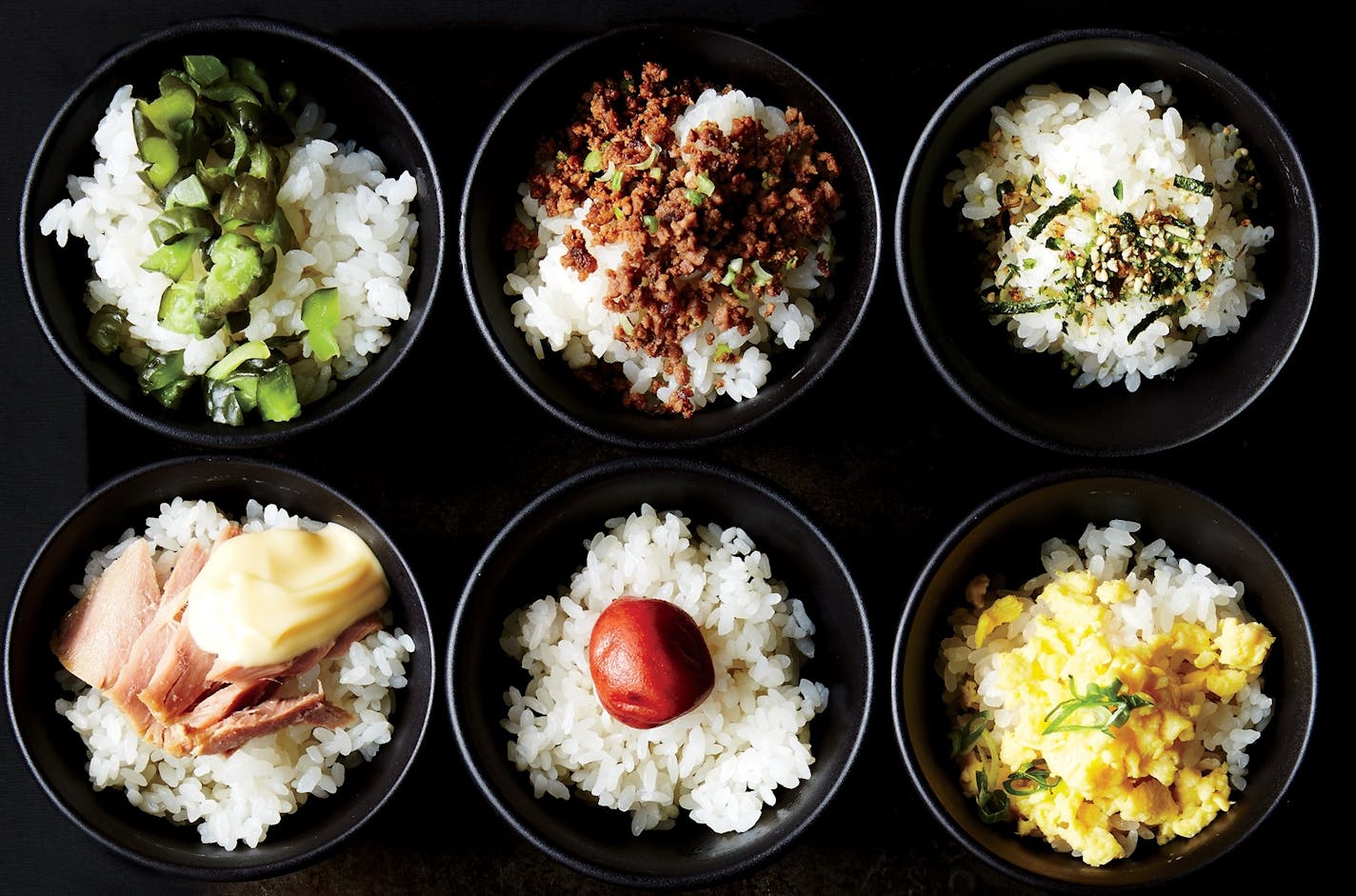 Toppings for rice include, from top left, pickled cucumber, Soboro beef, Furikake seasoning, and, from bottom left, tuna and mayo,
pickled plum, and scrambled egg with green onion.