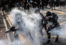 Protesters are engulfed in teargas in Wong Tai Sin, a working-class residential neighborhood in Hong Kong, on Monday, Aug. 5, 2019. Riot police office