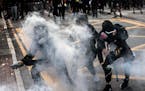 Protesters are engulfed in teargas in Wong Tai Sin, a working-class residential neighborhood in Hong Kong, on Monday, Aug. 5, 2019. Riot police office