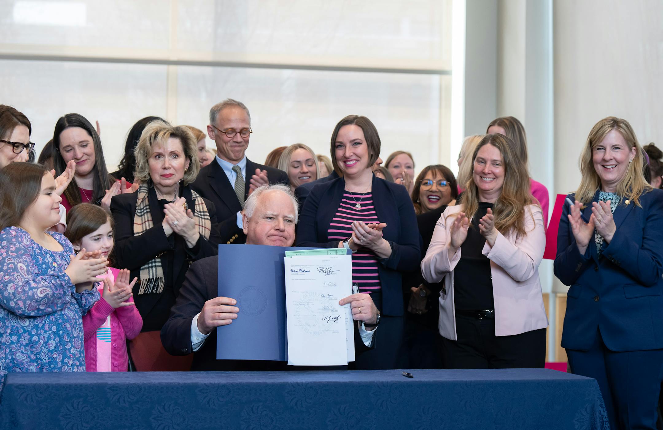 Surrounded by DFL legislators, Gov. Tim Walz signs a bill to add a "fundamental right" to abortion access into state law Tuesday, Jan. 31, 2023 St. Paul, Minn. Walz's signature makes Minnesota the sixteenth state to spell out a right to abortion access in its law books or constitution, and the first Legislature take such action since Roe was overturned last June.