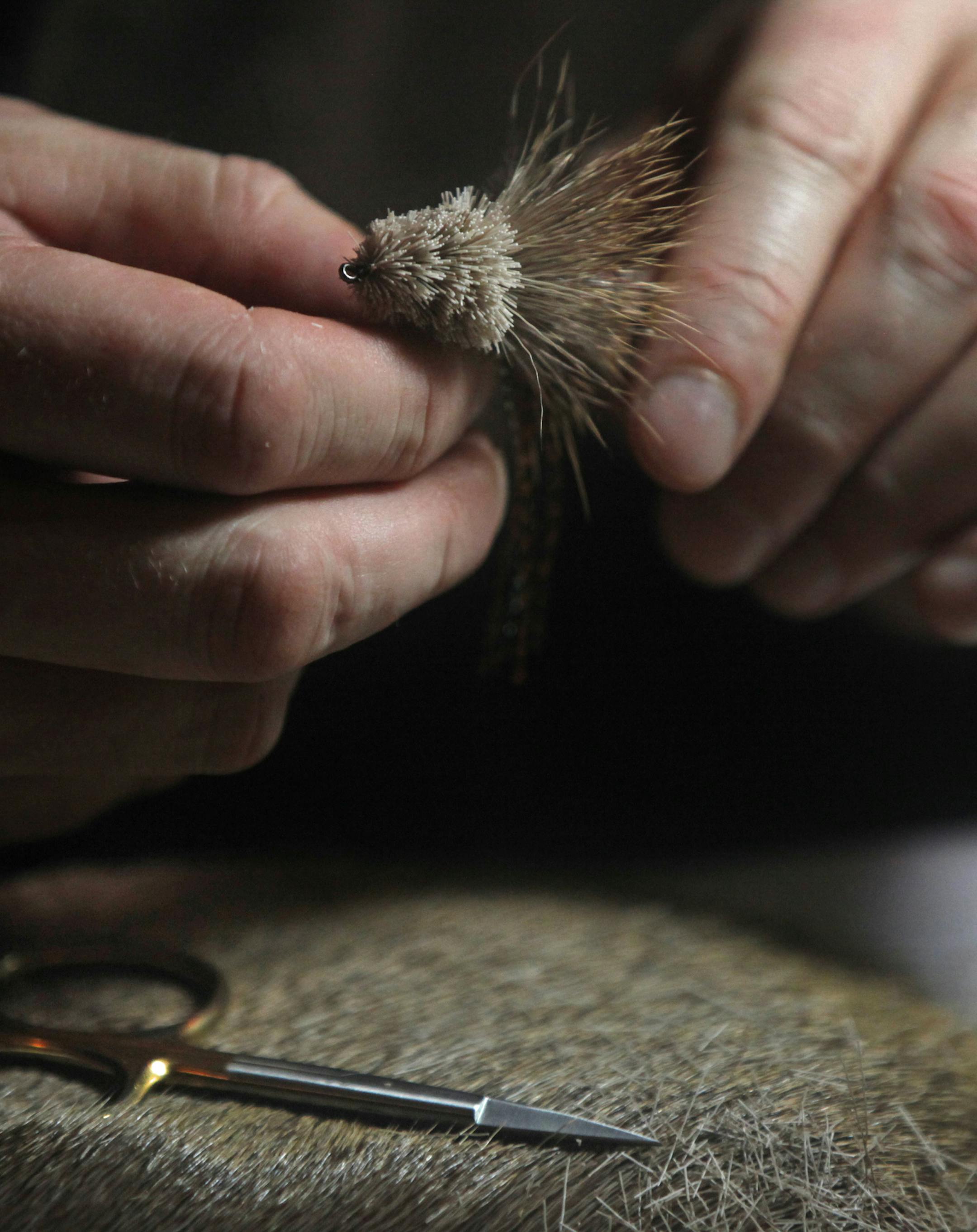 At Schroeder's Bar & Grill in St. Paul, Tony Stifter, who has been flyfishing since he was 12, ties a bass fly that includes the use of chicken feathers and deer hair.]richard tsong-taatarii/rtsong-taatarii@startribune.com ORG XMIT: MIN1312262205524181 ORG XMIT: MIN1401031419191032