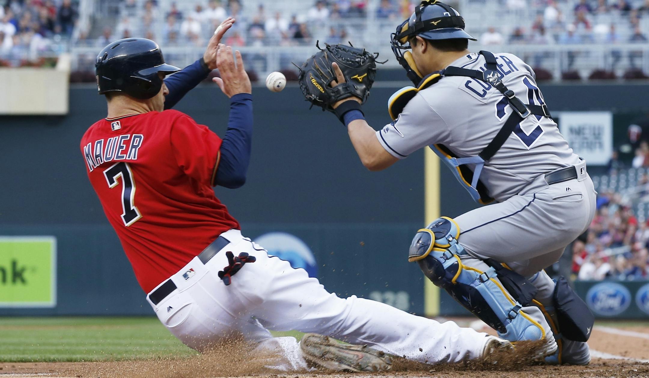 Minnesota Twins’ Joe Mauer slides in to score on a single by Trevor Plouffe as he beat the tag by Tampa Bay Rays catcher Hank Conger in the third inning of a baseball game Friday, June 3, 2016, in Minneapolis. (AP Photo/Jim Mone)