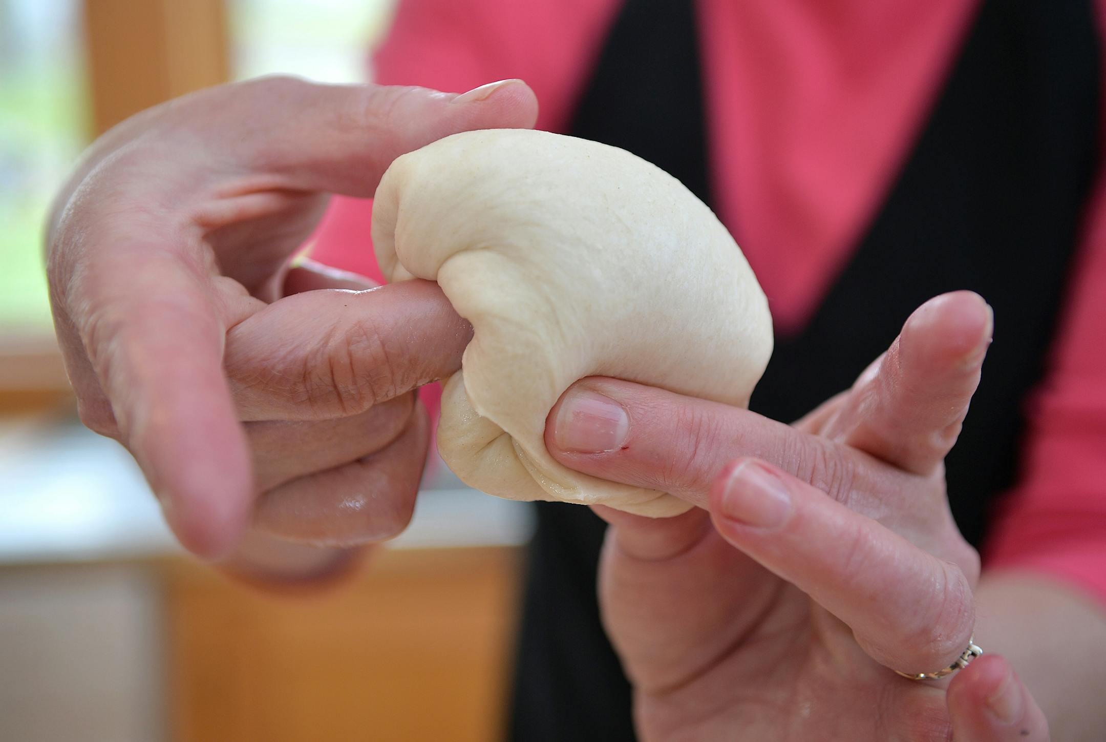 Fold the dough around one finger to form a traditional hamburger bun shape. ] (SPECIAL TO THE STAR TRIBUNE/BRE McGEE)