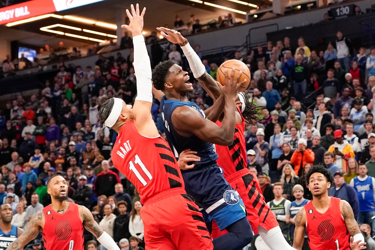 Minnesota Timberwolves guard Anthony Edwards, center, goes up for a shot past Portland Trail Blazers forward Josh Hart, left, and forward Jerami Grant during the second half of an NBA basketball game, Wednesday, Jan. 4, 2023, in Minneapolis. Edwards had 32 points as the Timberwolves won 113-106. (AP Photo/Craig Lassig)