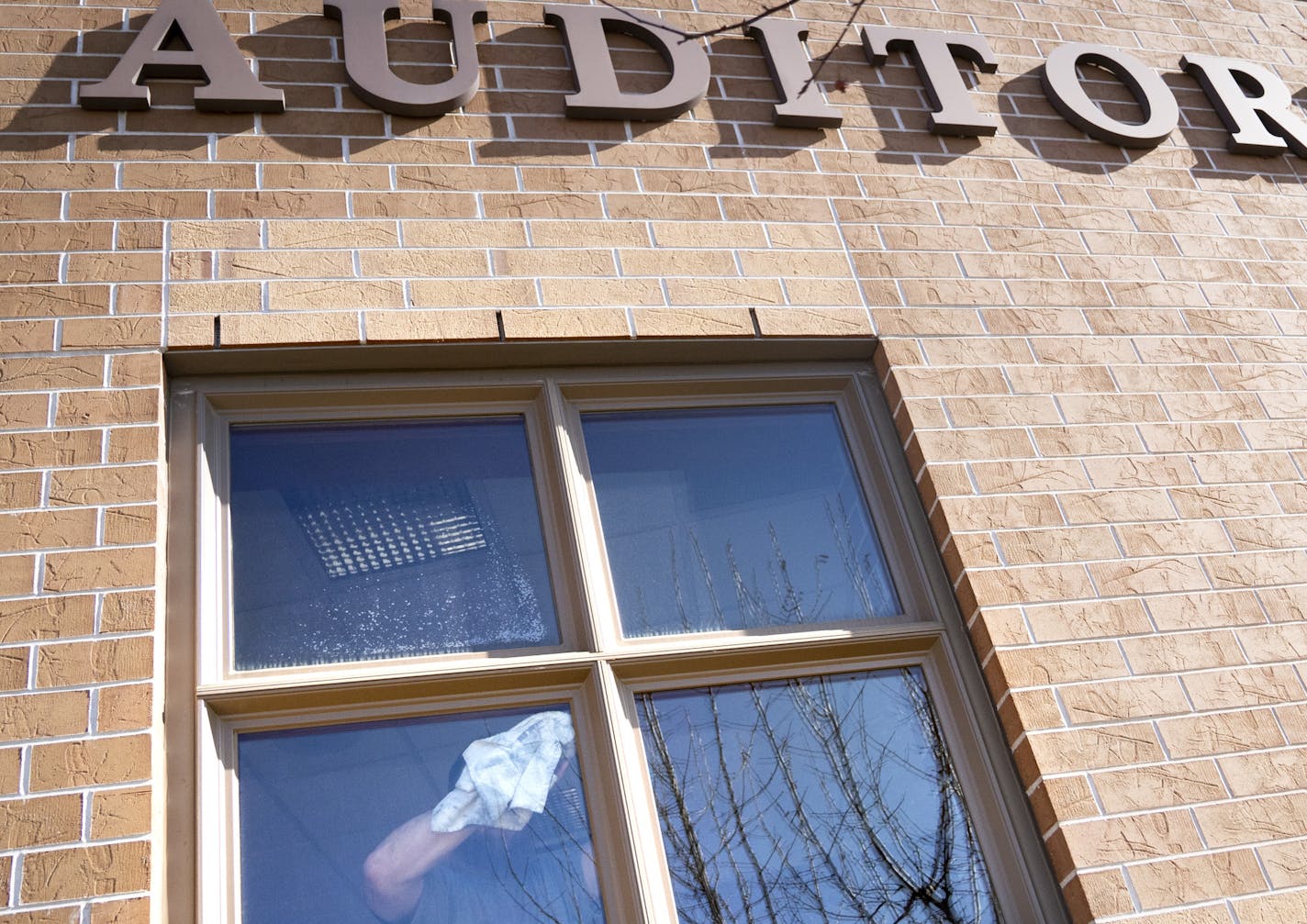 A man cleaned windows in the auditorium entrance of Osceola High School in Osceola, Wis., on Tuesday, March 10, 2020, after it was discovered someone testing positive for the coronavirus attended a function Saturday at the school. The school was closed for cleaning. ] RENEE JONES SCHNEIDER &#xa5; renee.jones@startribune.com