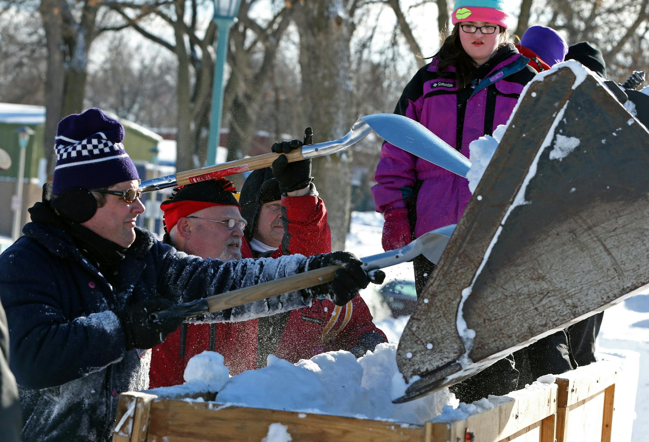 Volunteers packed snow into a huge block form to even out the level. Former Vulcans, friends, family and other volunteers gathered at the Minnesota State Fairgrounds to stomp snow in preparation for the Winter Carnival Snow Sculpting Contest. The snow was blowen into the forms then packed down to form the sculpture cubes. This year's St. Paul Winter Carnival will feature a giant snow slide, an attempt to break the record for the world's largest snowball fight and an outdoor winter baseball game.