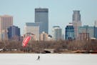 Kite boarders skim across Bde Maka Ska in front of the Minneapolis skyline in March. The state's famous winters are warming 13 times faster than its s