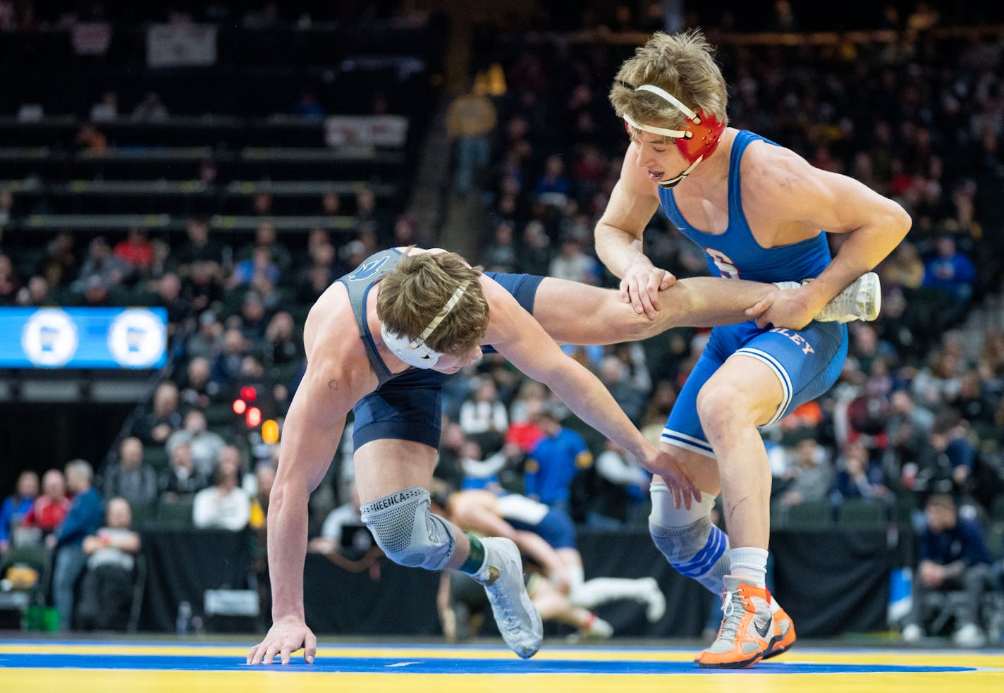 Simley wrestler Cash Raymond grabs the leg of Zumbrota wrestler Kaleb Lochner during the MSHSL wrestling state tournament Friday, March 3, 2023 at Xcel Energy Arena in St. Paul, Minn. ]