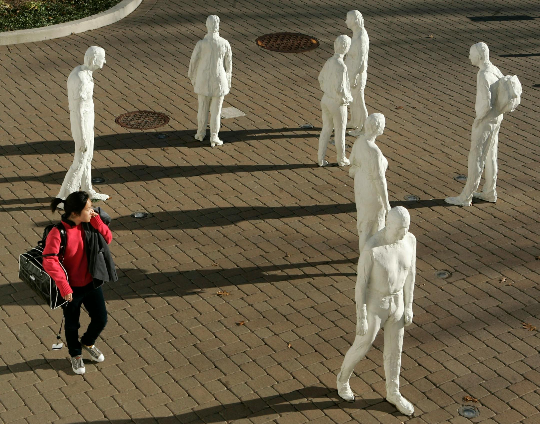 A Montclair State University student uses a cell phone as she walks past an outdoor sculpture called Street Crossing by George Segal on the campus in Montclair, N.J., Wednesday, Nov. 28, 2007. Montclair is one of the first schools in the U.S. to use GPS tracking devices, which along with other security technology are increasingly being adopted on campuses in the wake of the Virginia Tech massacre last spring.