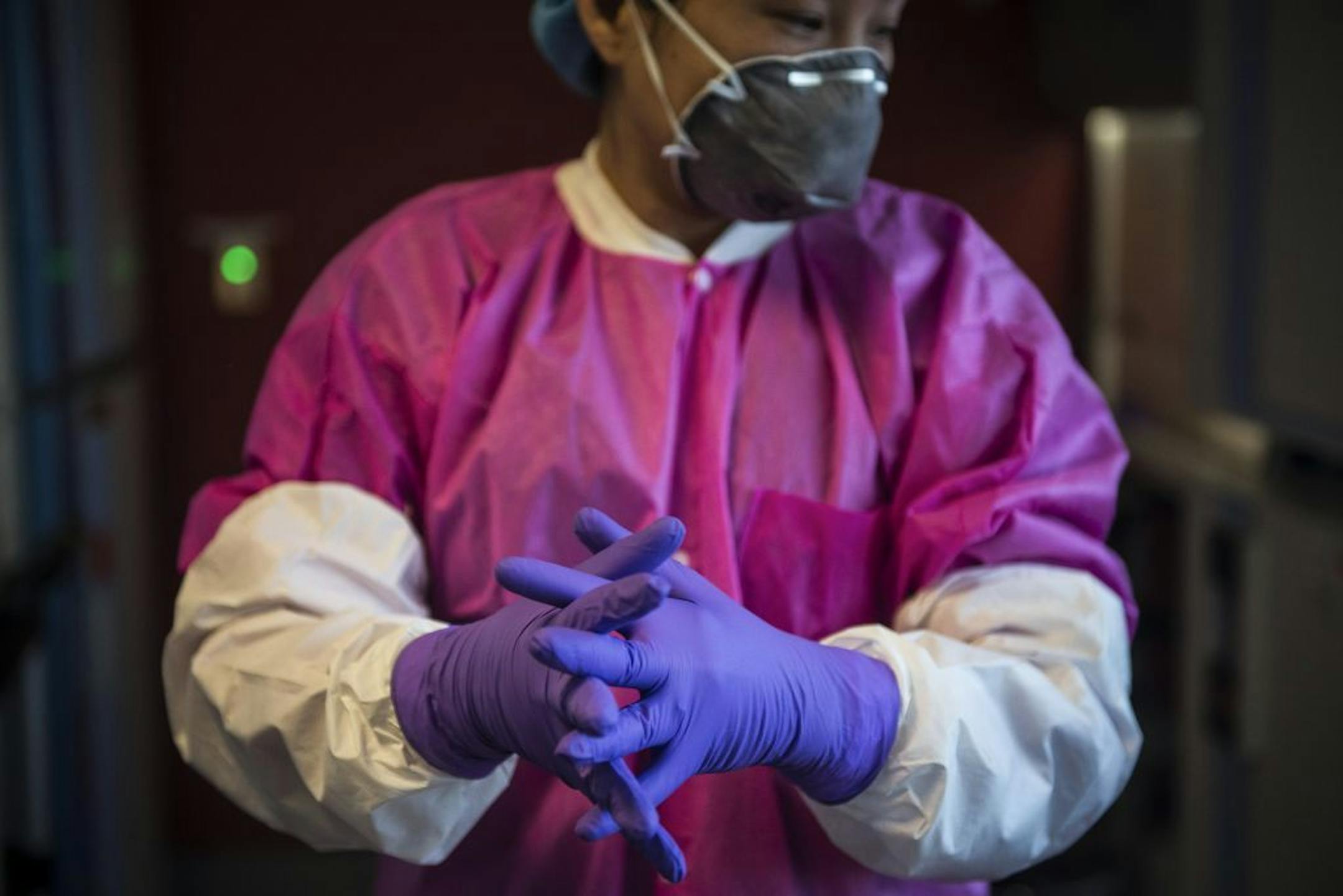 Miao Xu dresses into protective gear before working with the Zika virus in the lab at the National Center for Advancing Translational Sciences, which is testing drugs on neural progenitor cells, hoping to find compounds that can stop the Zika virus, in Bethesda, Md., April 6, 2016. A graduate student�s offhand remark has led to widespread research of the Zika virus that has provided findings about how the virus causes brain damage.