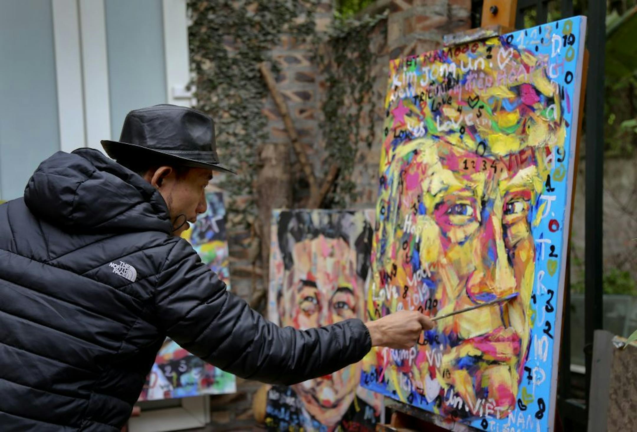 In this Feb. 25, 2019, photo, Tran Lam Binh puts the final touches to a portrait of U.S. President Donald Trump in Hanoi, Vietnam. Binh's portrait series of U.S. President Donald Trump and North Korean leader Kim Jong Un is to mark the two leaders' second summit to be held in Hanoi this week.