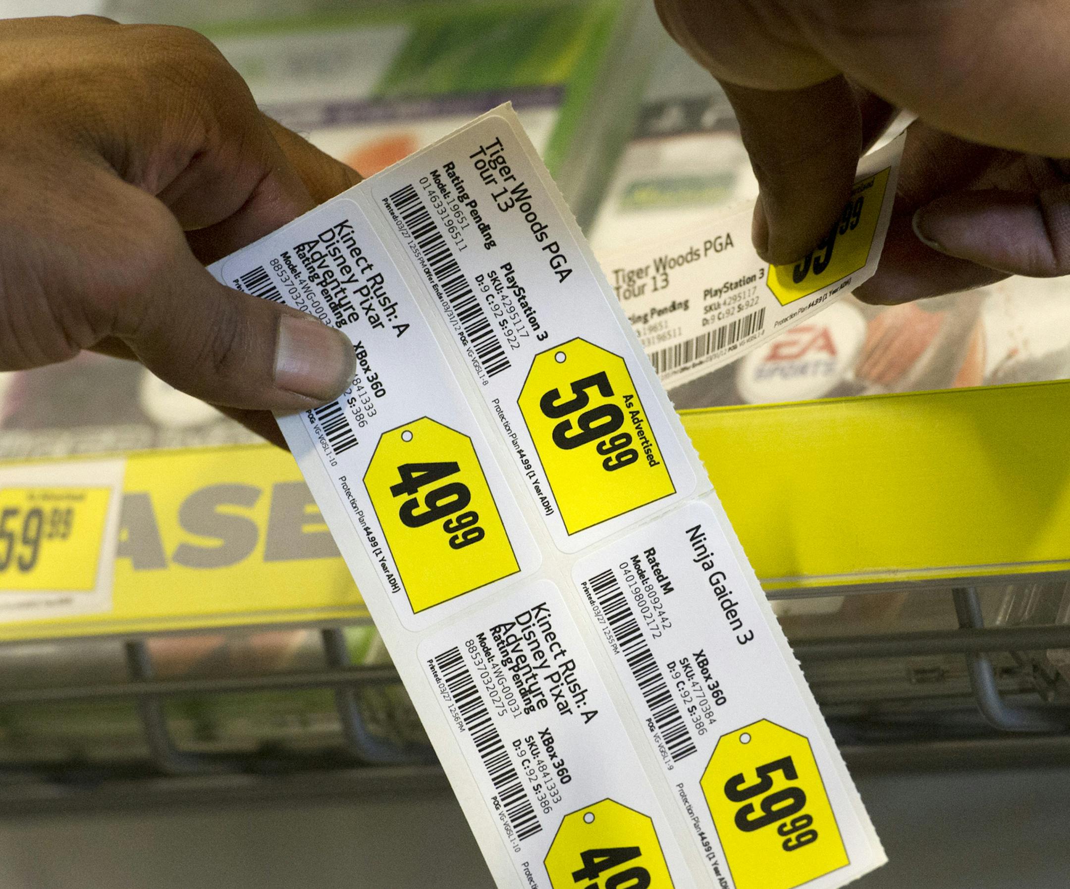 An employee attaches price tags to displays at a Best Buy Co. store in Emeryville, California, U.S., on Tuesday, March 27, 2012. Best Buy Co., the electronics, appliance and entertainment retailer, is expected to release quarterly earnings on March 29. Photographer: David Paul Morris/Bloomberg ORG XMIT: 142118105