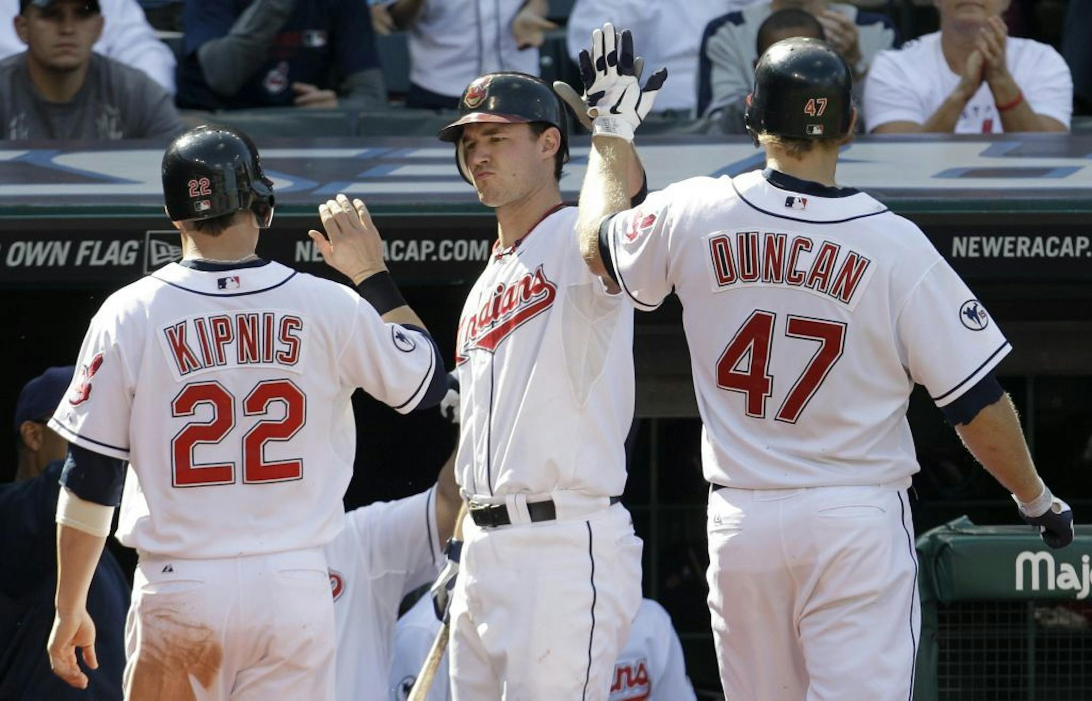 Cleveland Indians' Jack Hannahan, center, high-fives Shelley Duncan after Duncan hit a sacrifice fly in the sixth inning in the first baseball game of a doubleheader against the Minnesota Twins, Saturday, Sept. 24, 2011, in Cleveland. Jason Kipnis, left, scored. The Indians won 8-2.