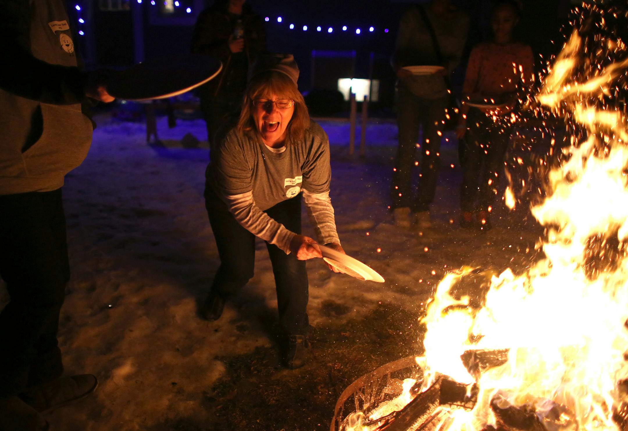 Kathy Landucci laughed after her plate didn't break in the bonfire as part of the celebration. ] (KYNDELL HARKNESS/STAR TRIBUNE) kyndell.harkness@startribune.com At the ninth annual LungLeavin' Day in Roseville, Min., Saturday, February 7, 2015.