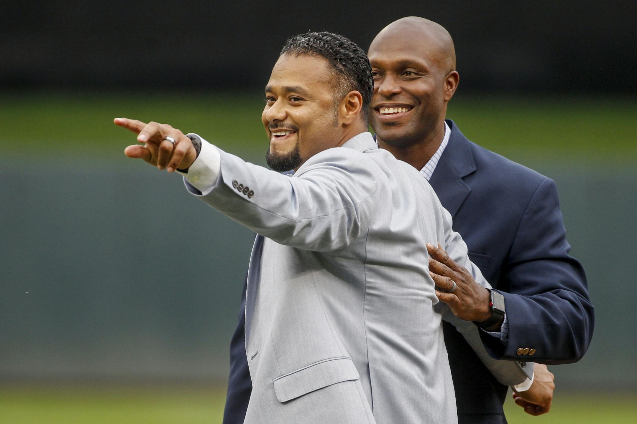 Former Twins pitcher Johan Santana points to his teammates with Torii Hunter at his induction ceremony to the Minnesota Twins Hall of Fame before the baseball game with the Kansas City Royals on Saturday, Aug. 4, 2018, in Minneapolis.