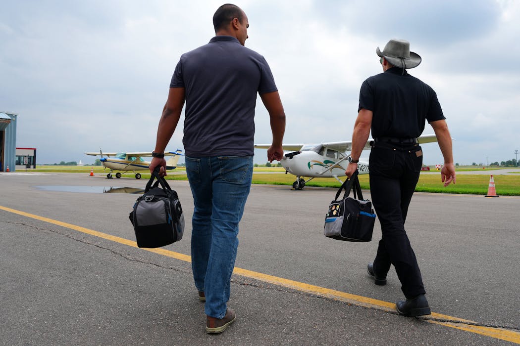 Jacob Berk, right, a flight instructor earning hours in his job toward meeting the requirement to fly for a major carrier, talked with student Jeetan Karki of Richfield as they walked toward their plane at Flying Cloud Airport in Eden Prairie.
