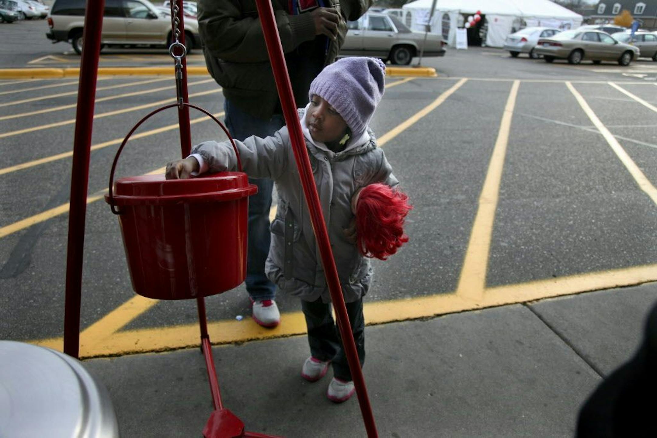 Three-year-old Lauren Walker joined her mother Latrice Jackson to a trip to the Salvation Army kettle to give before they shop at the St. Louis Park Cub Foods, Wednesday, November 9, 2011. (ELIZABETH FLORES/STAR TRIBUNE) ELIZABETH FLORES � eflores@startribune.com