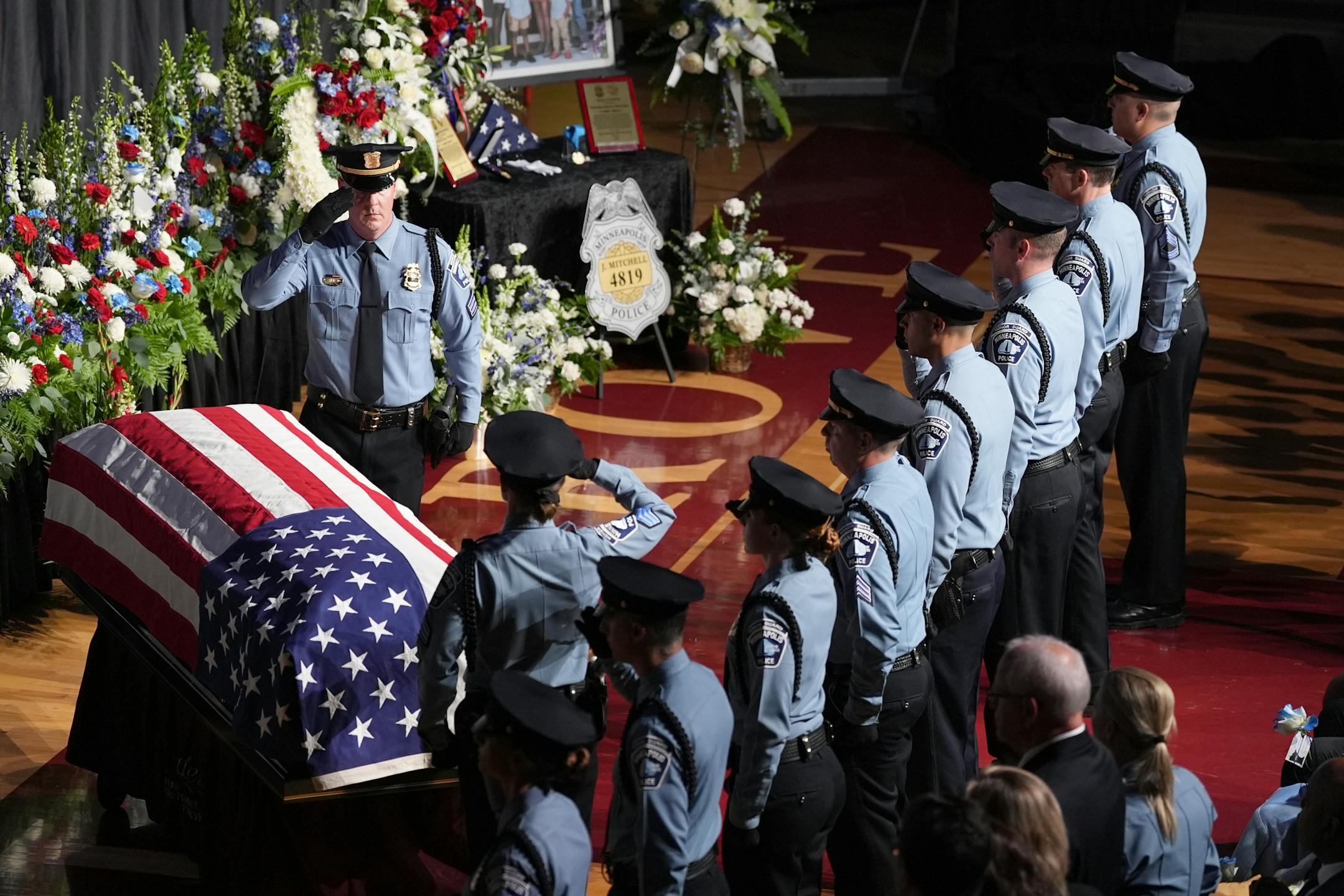 Law enforcement officers salute during a public memorial service for Minneapolis police Officer Jamal Mitchell at Maple Grove Senior High School, Tuesday, June 11, 2024, in Maple Grove, Minn. Mitchell was shot and killed while responding to a shooting on May 30, 2024. (AP Photo/Abbie Parr, Pool)
