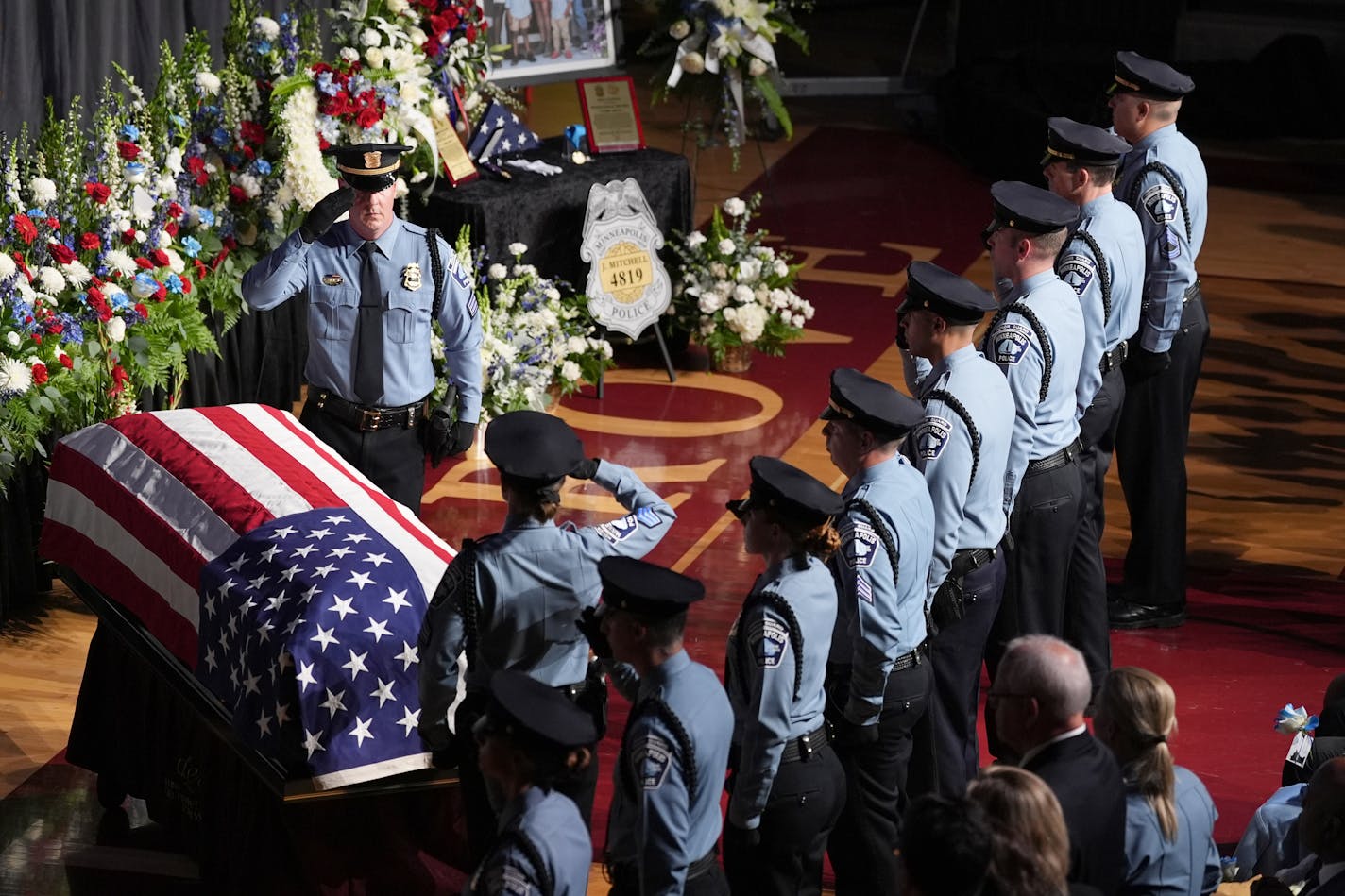 Law enforcement officers salute during a public memorial service for Minneapolis police Officer Jamal Mitchell at Maple Grove Senior High School, Tuesday, June 11, 2024, in Maple Grove, Minn. Mitchell was shot and killed while responding to a shooting on May 30, 2024. (AP Photo/Abbie Parr, Pool)