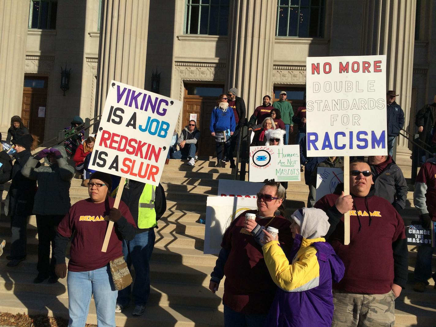 Protesters march in opposition to the Washington Redskins name.