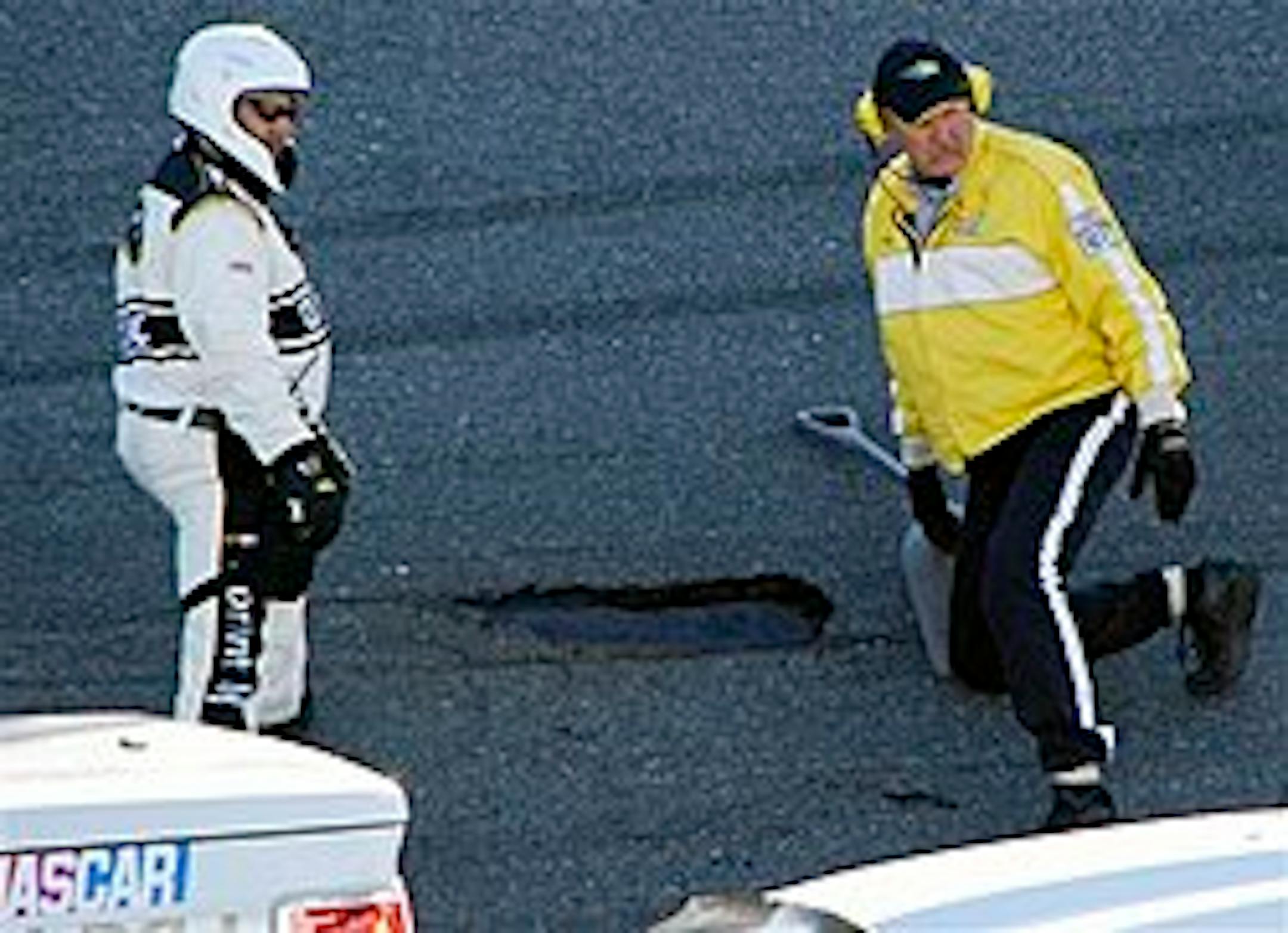 NASCAR and track officials examine a pothole in the track during the NASCAR Daytona 500 auto race at Daytona International Speedway in Daytona Beach, Fla., Sunday, Feb. 14, 2010. (AP Photo/Russell Williams)