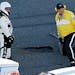 NASCAR and track officials examine a pothole in the track during the NASCAR Daytona 500 auto race at Daytona International Speedway in Daytona Beach, 