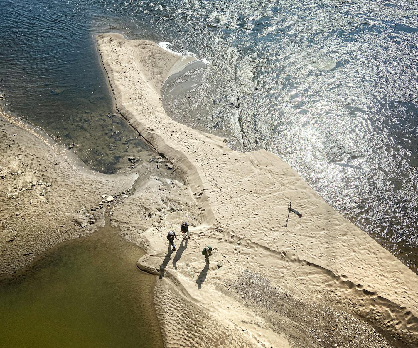 People wandered the Mississippi River bottom Monday below the Stone Arch Bridge as the Army Corps of Engineers lowered the river to allow inspection of the upper and lower lock and dams.