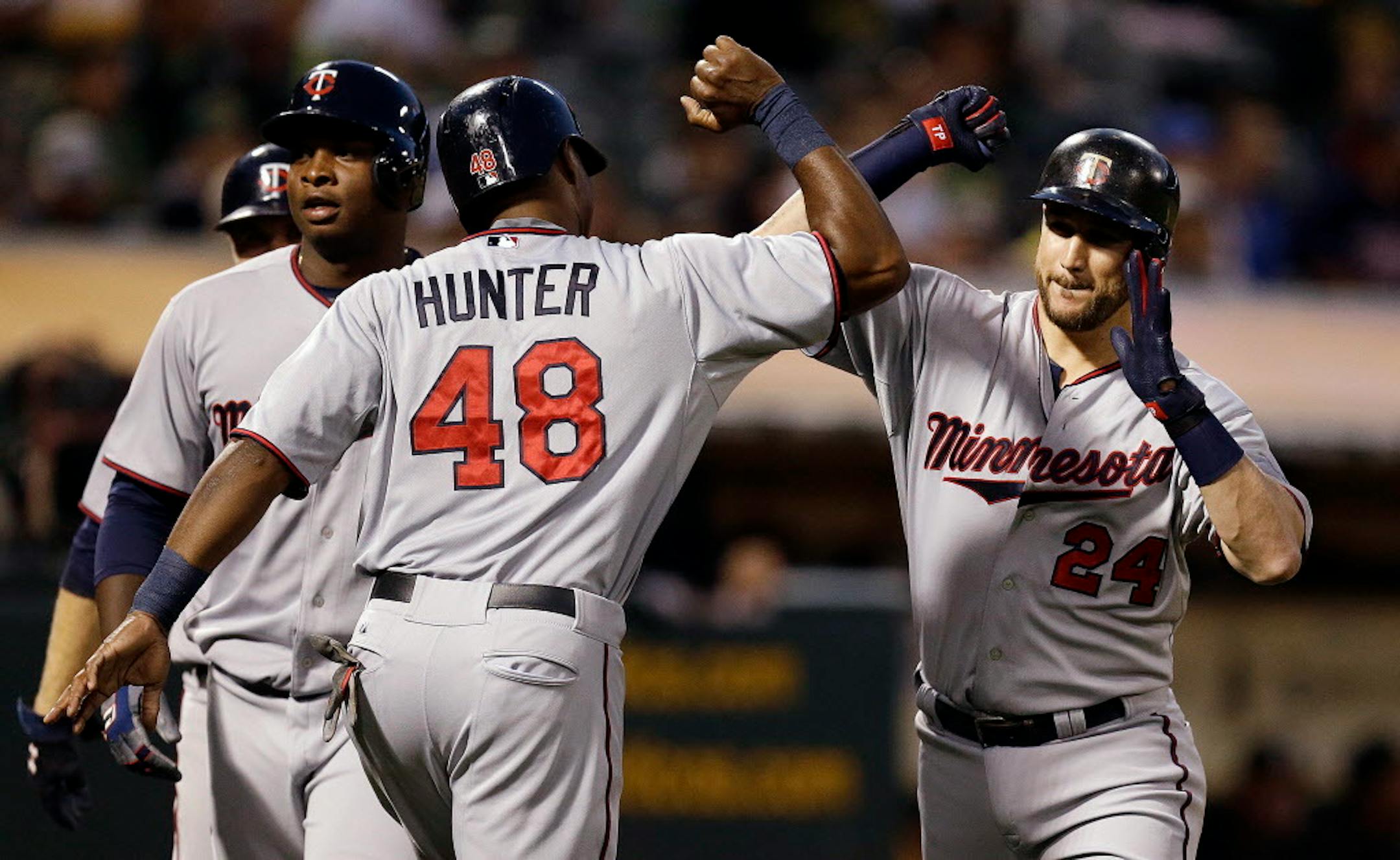 Minnesota Twins' Torii Hunter (48) celebrates with Trevor Plouffe, right, after Plouffe hit a grand slam off Oakland Athletics' Sonny Gray during the sixth inning of a baseball game Friday, July 17, 2015, in Oakland, Calif. (AP Photo/Ben Margot)