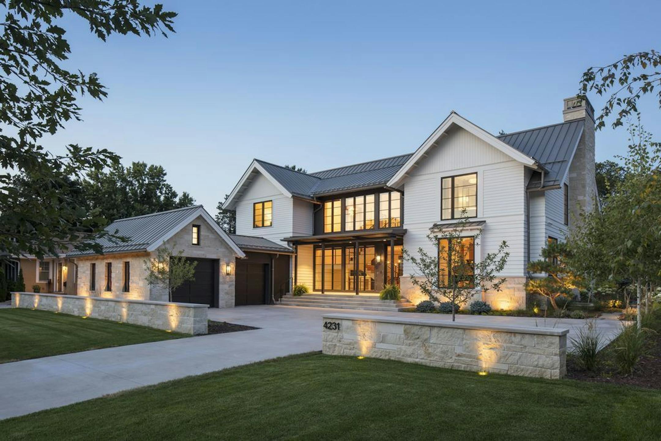 A transparent glass entryway connects two gables in this modern farmhouse by Andrea Swan, Swan Architecture.