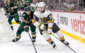 Jonas Brodin (25) of the Wild and William Karlsson (71) of the Vegas Golden Knights battle for the puck in the second period at Xcel Energy Center in