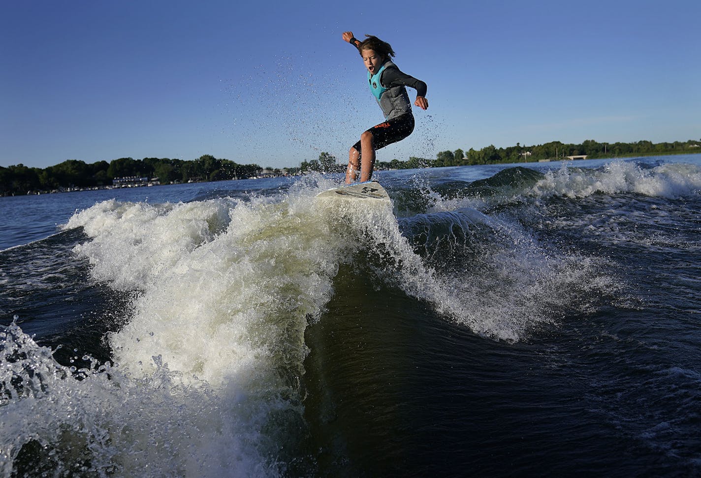 Bethany Anderson, 13, wake boards Friday on Lake Minnetonka in Orono, MN. The Anderson family is among a growing population that participate in the water sport but some home owners on the lake would restrict the use of wake boats that produce the waves for wake boarding.