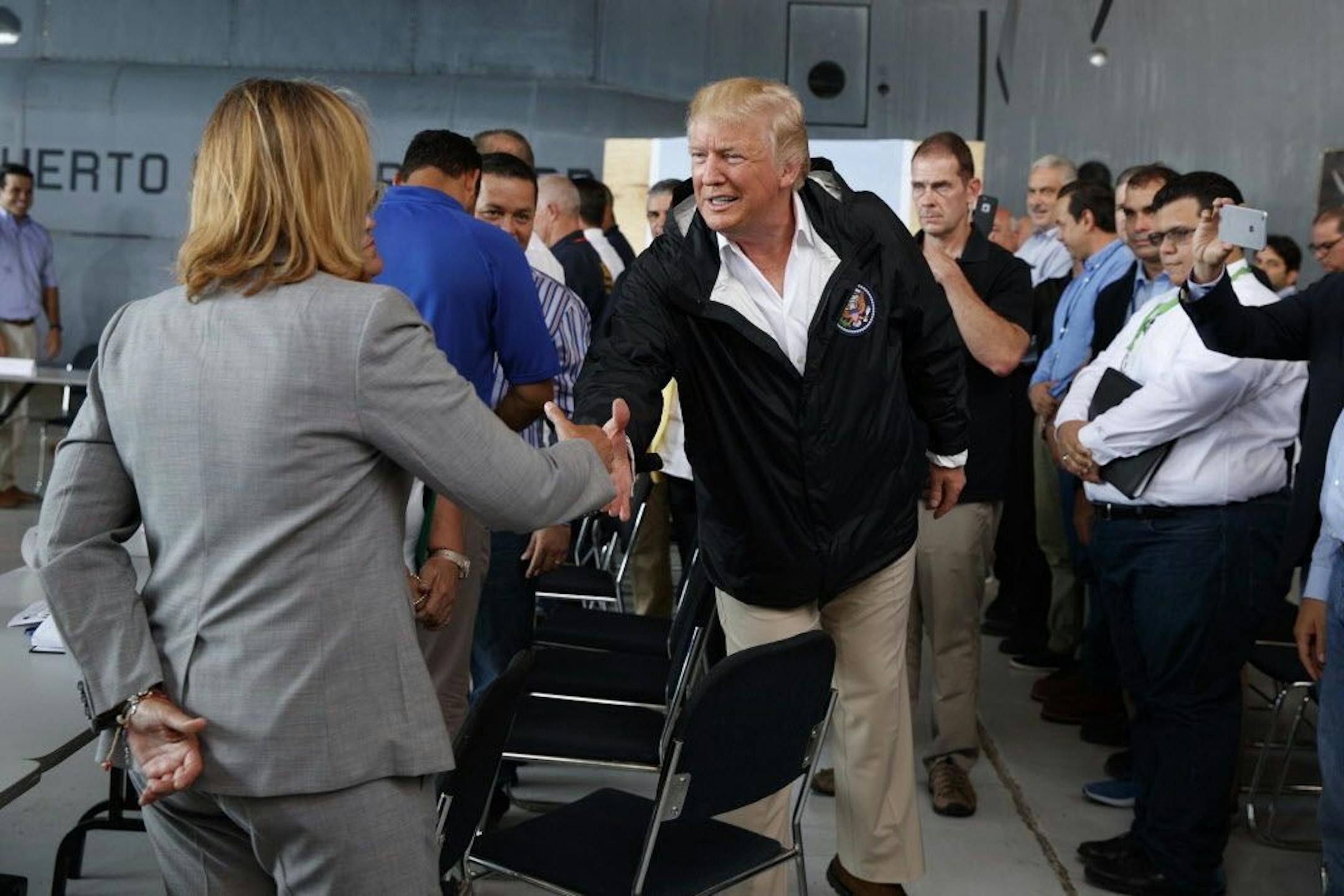 President Donald Trump shook hands with San Juan Mayor Carmen Yulin Cruz during a briefing on hurricane recovery efforts with first responders at Luis Muniz Air National Guard Base, Tuesday, Oct. 3, 2017, in San Juan, Puerto Rico.