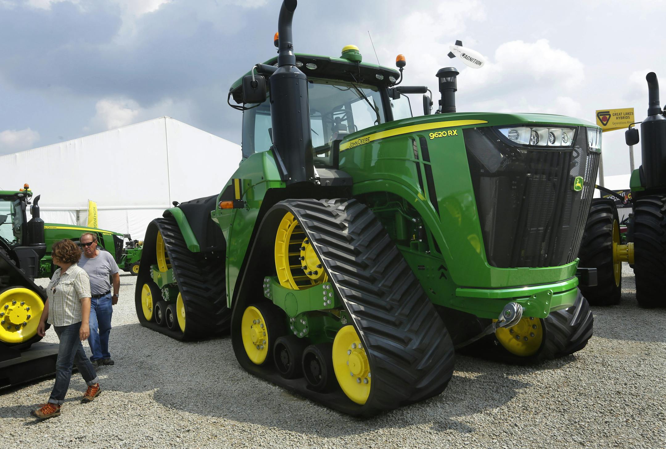 FILE - In this Monday, Aug. 31, 2015, file photo, Douglas and Monika Johnson from Perry, Iowa, look at John Deere equipment on display at the Farm Progress Show in Decatur, Ill. Deere & Co. report financial results Friday, Aug. 19, 2016. (AP Photo/Seth Perlman, File) ORG XMIT: NYBZ501