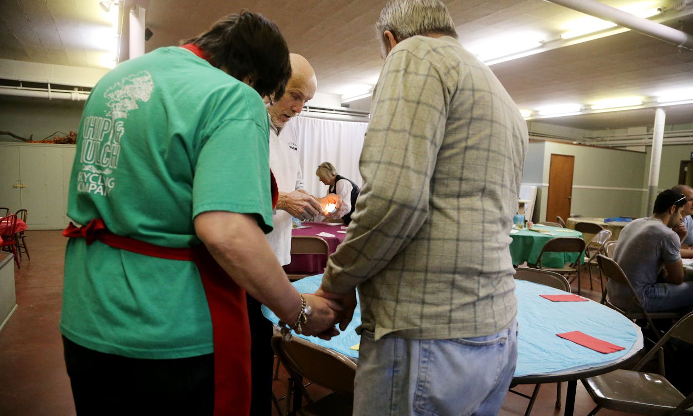 Volunteer Owen Green lights a candle for the table of diners Valerie Ludvigson of Minneapolis and her dad Doug Ludvigson at the Soup for You! Cafe Tuesday, March 31, 2015, at Bethany Lutheran Church in Minneapolis, MN. Valerie Ludvigson suffered a traumatic brain injury and is limited in her ability to get out and dine but tries to make a habit of getting to the Soup for You! Cafe. "I love the soup," she says. "I'm trying to figure out which soup to eat first."](DAVID JOLES/STARTRIBINE)djoles@st