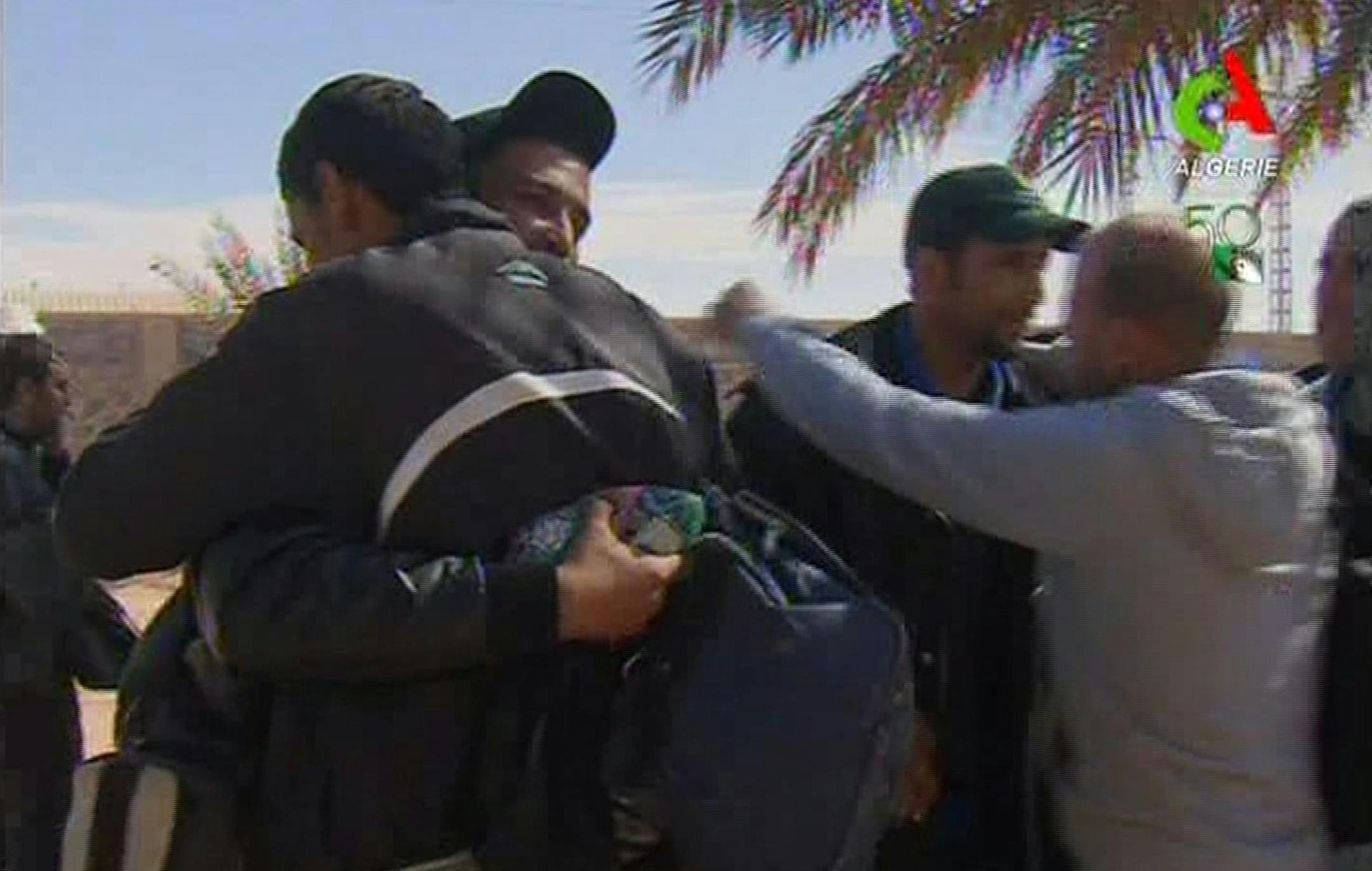 Rescued hostages hug each other in Ain Amenas, Algeria, in this image taken from television Friday Jan. 18, 2013. Algeria's state news service says nearly 100 out of 132 foreign hostages have been freed from a gas plant where Islamist militants had held them captive for three days.