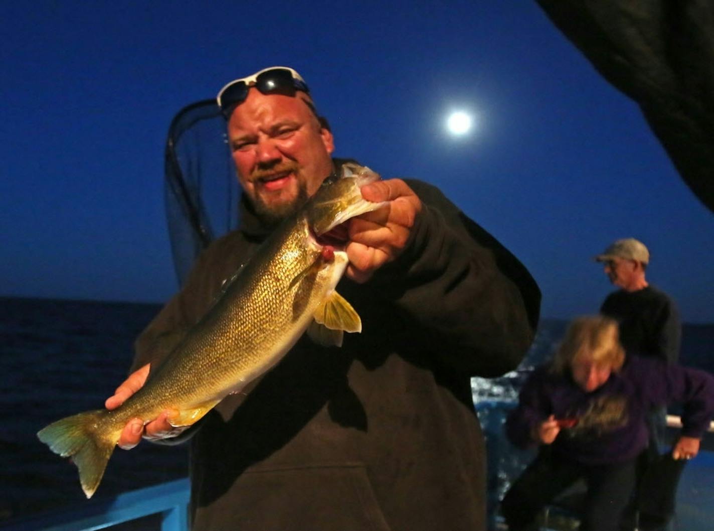 Travis Koster, Twin Pines Resort boat captain and fishing guide holds up a 21 1/2 inch walleye that was released Wednesday, July 29, 2015, caught by client Barb Stirling of Iowa during an evening excursion on Lake Mille Lacs.