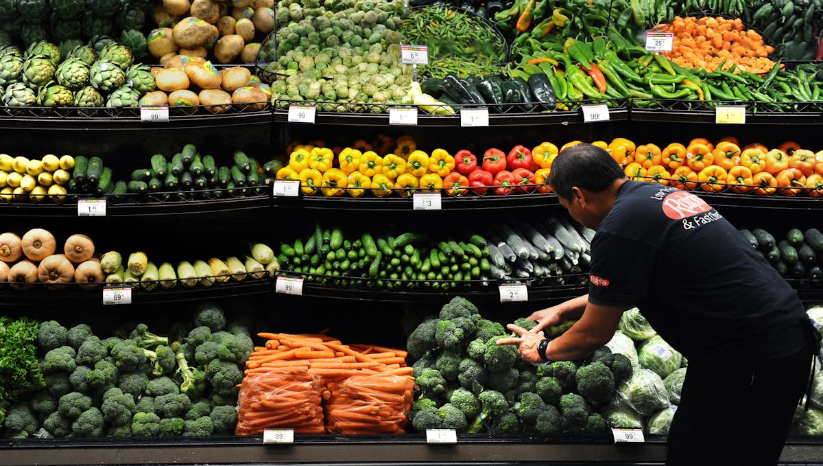 Produce clerk Frank Duenas arranged vegetables at a grocery store in downtown Los Angeles. Declining food prices are problem for grocery retailers lik