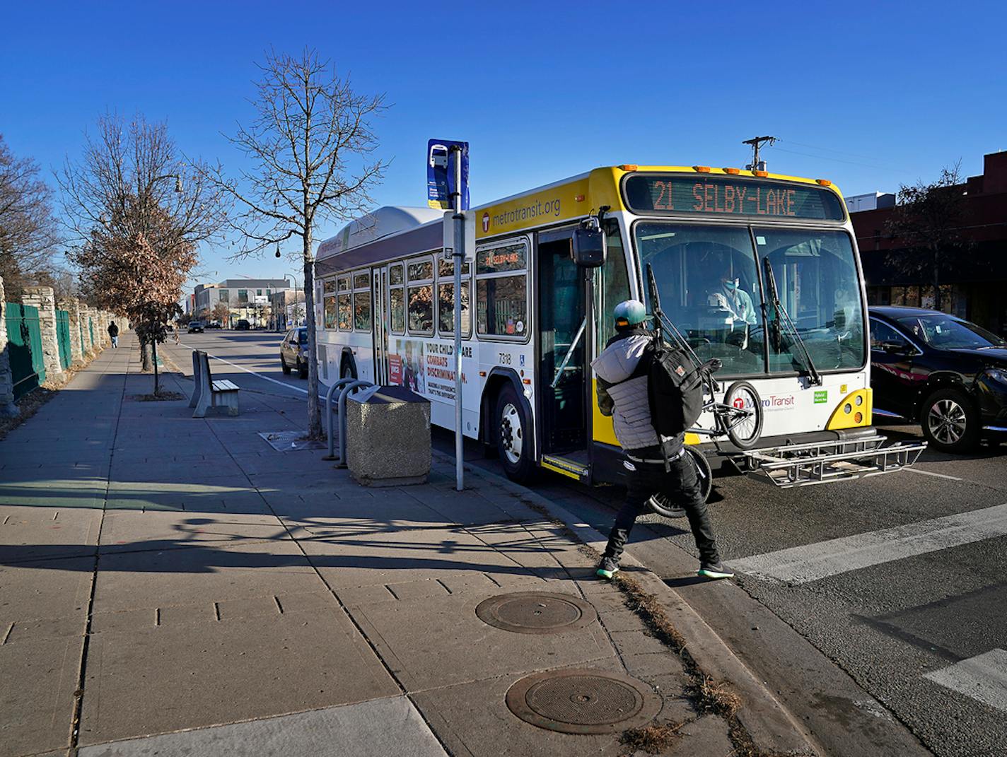 A rider with a bicycle pulls the bike off a rack on a Metro Transit route 21 bus traveling west along Lake Street at Cedar Ave. S. Wednesday in Minneapolis. ]