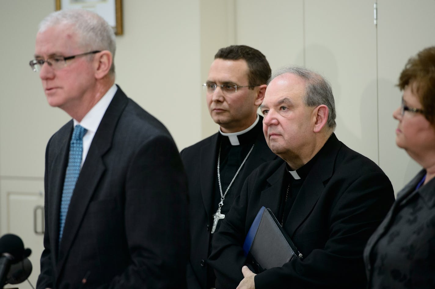 Archbishop Bernard Hebda, right and Auxiliary Bishop Andrew Cozzens listened as Director of Office of Ministerial Standards and Safe Environment Judge Tim O'Malley spoke about the agreement. They did not take questions.